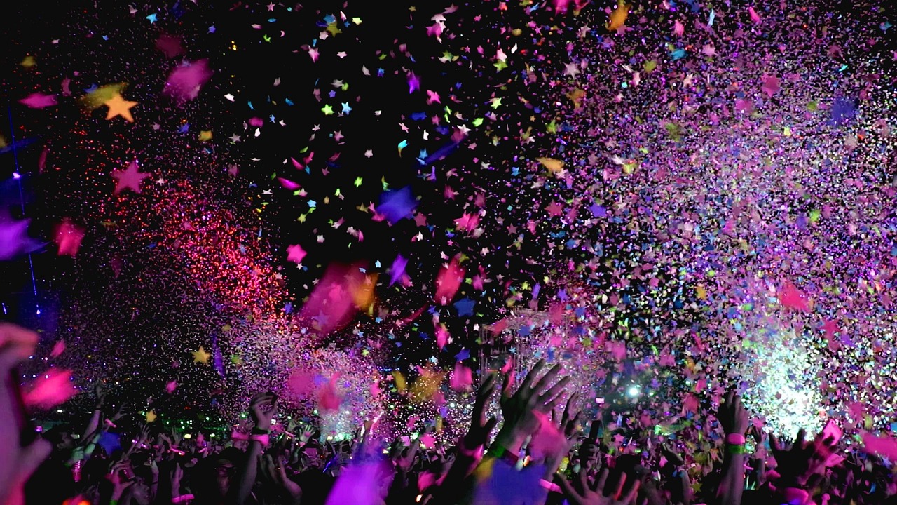 Photograph of purplish confetti being thrown at a concert