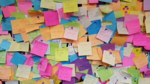 Photograph of colorful but messy post-its on a wall