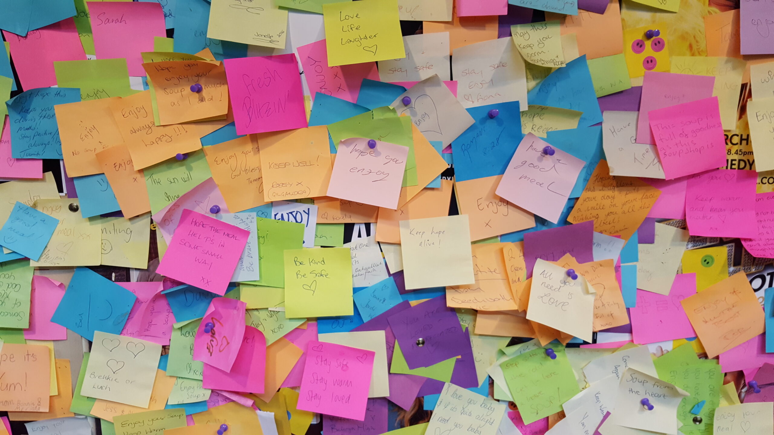 Photograph of colorful but messy post-its on a wall