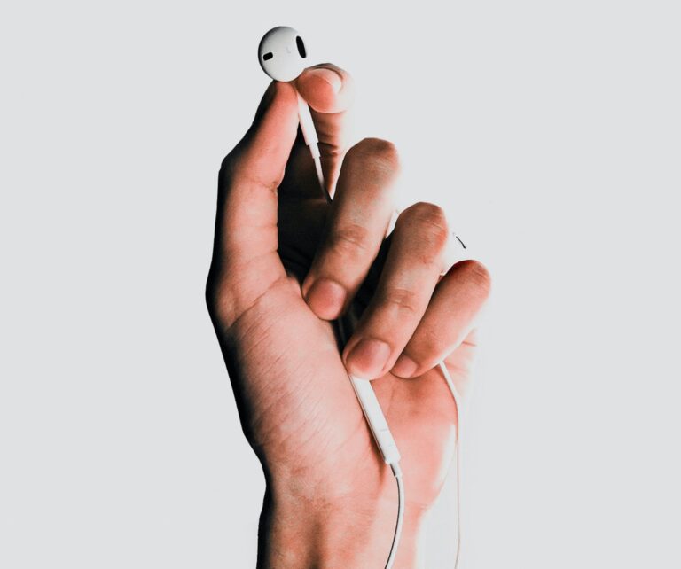 An image of a hand holding an earbud.
