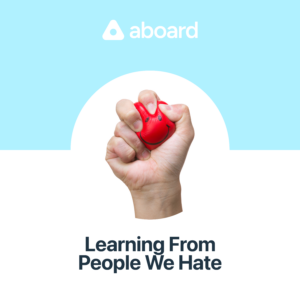 Episode cover. Image of a hand squeezing a red smiley face ball. Background split between sky blue and white. White aboard logo at top, black text title at bottom: Learning From People We Hate.