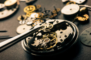 Photograph of a set of pliers working on the gears of a watch