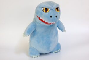 A photograph of a stuffed light blue dinosaur.