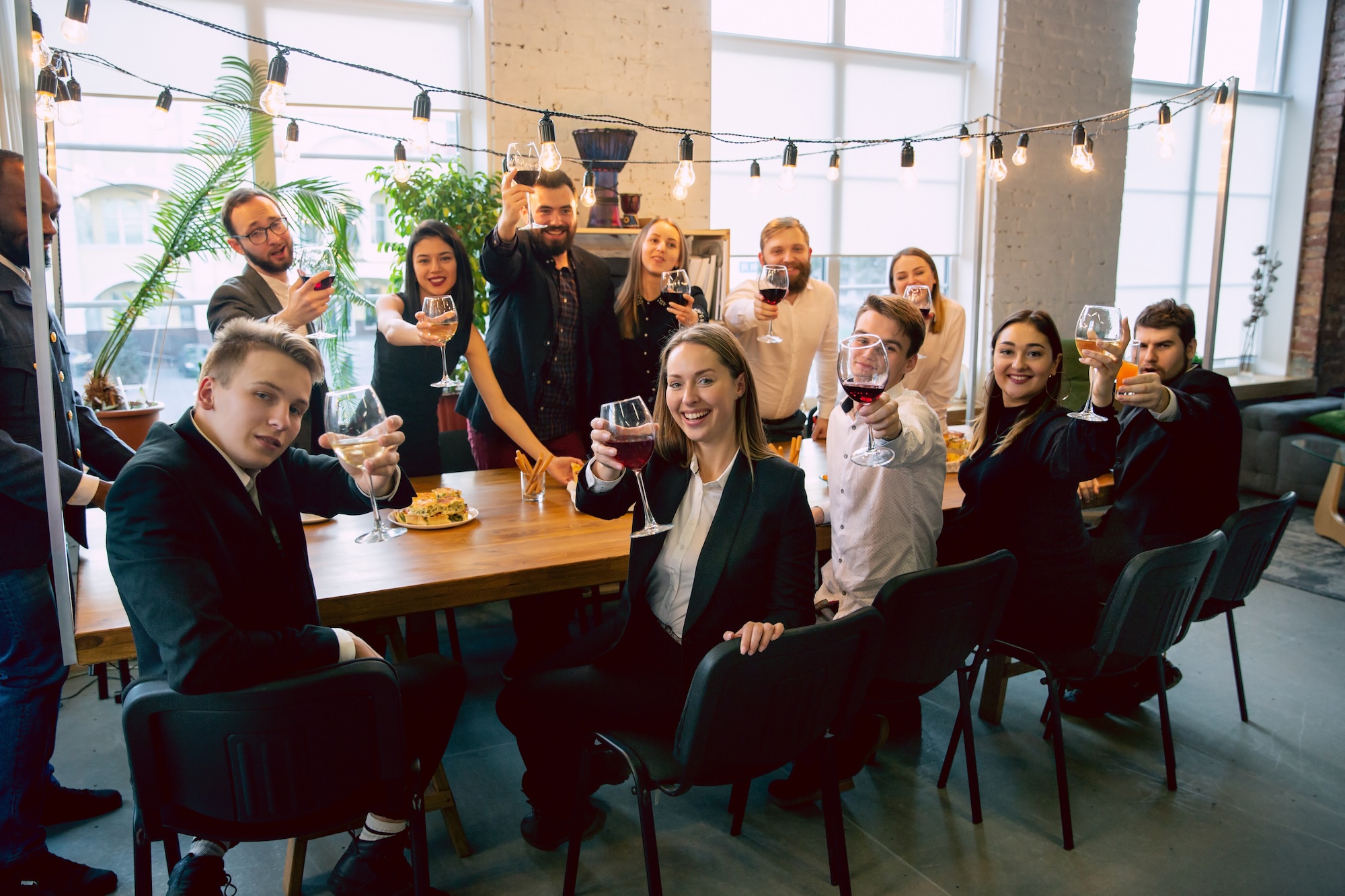 Photograph of a group of coworkers at a board table raising their glasses in a toast.