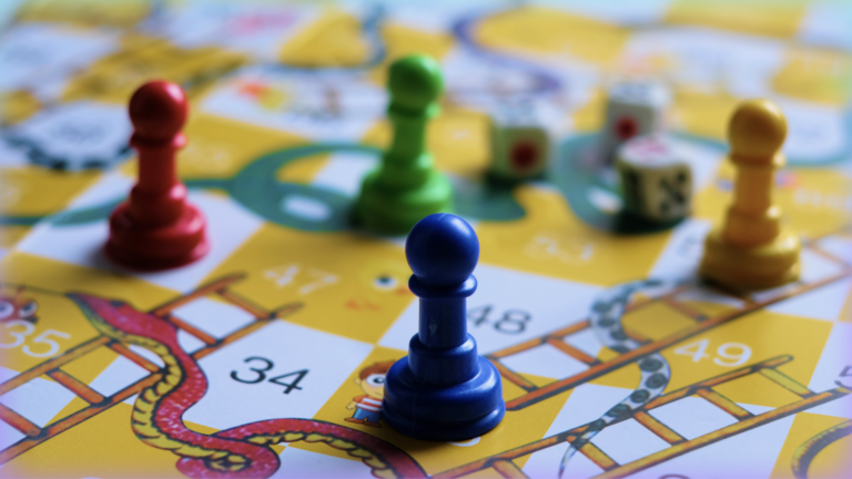 Close-up image of pegs on a board of the game Chutes and Ladders.