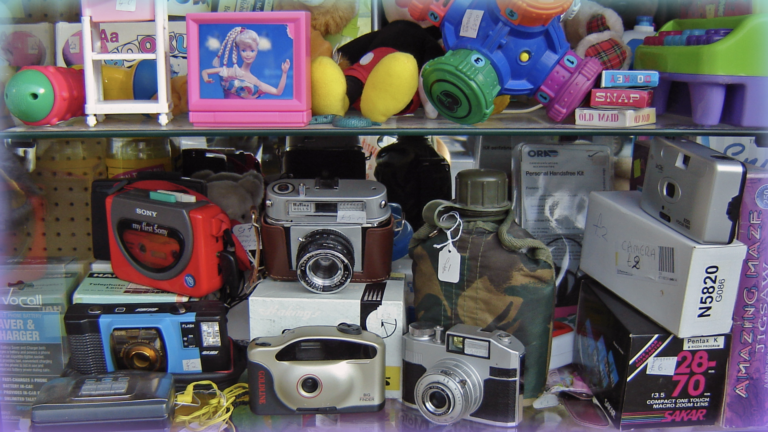 Image of a set of shelves in a thrift store with a hodgepodge of items.