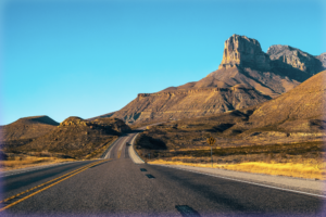 Driver's-perspective photograph of an open road in the American Southwest.