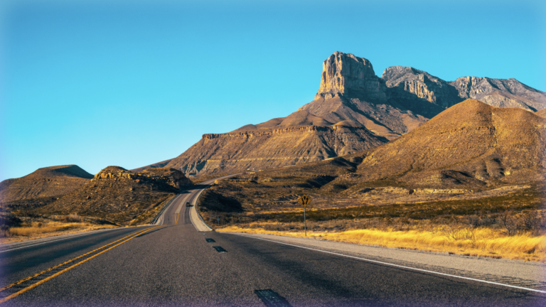 Driver's-perspective photograph of an open road in the American Southwest.