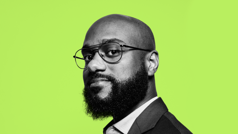 Black and white headshot of Patrick (in a blazer and collared shirt, with glasses) against a hot green background.