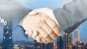 Somewhat ironic image of two hands shaking in front of a cityscape.