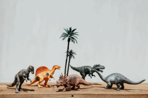 Image of toy dinosaurs and toy palm trees.
