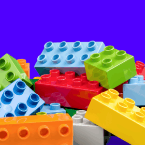 Image of a pile of classic multicolored legos against a dark purple-blue background.