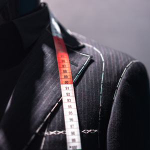 Image of the shoulder of a suit jacket being tailored.