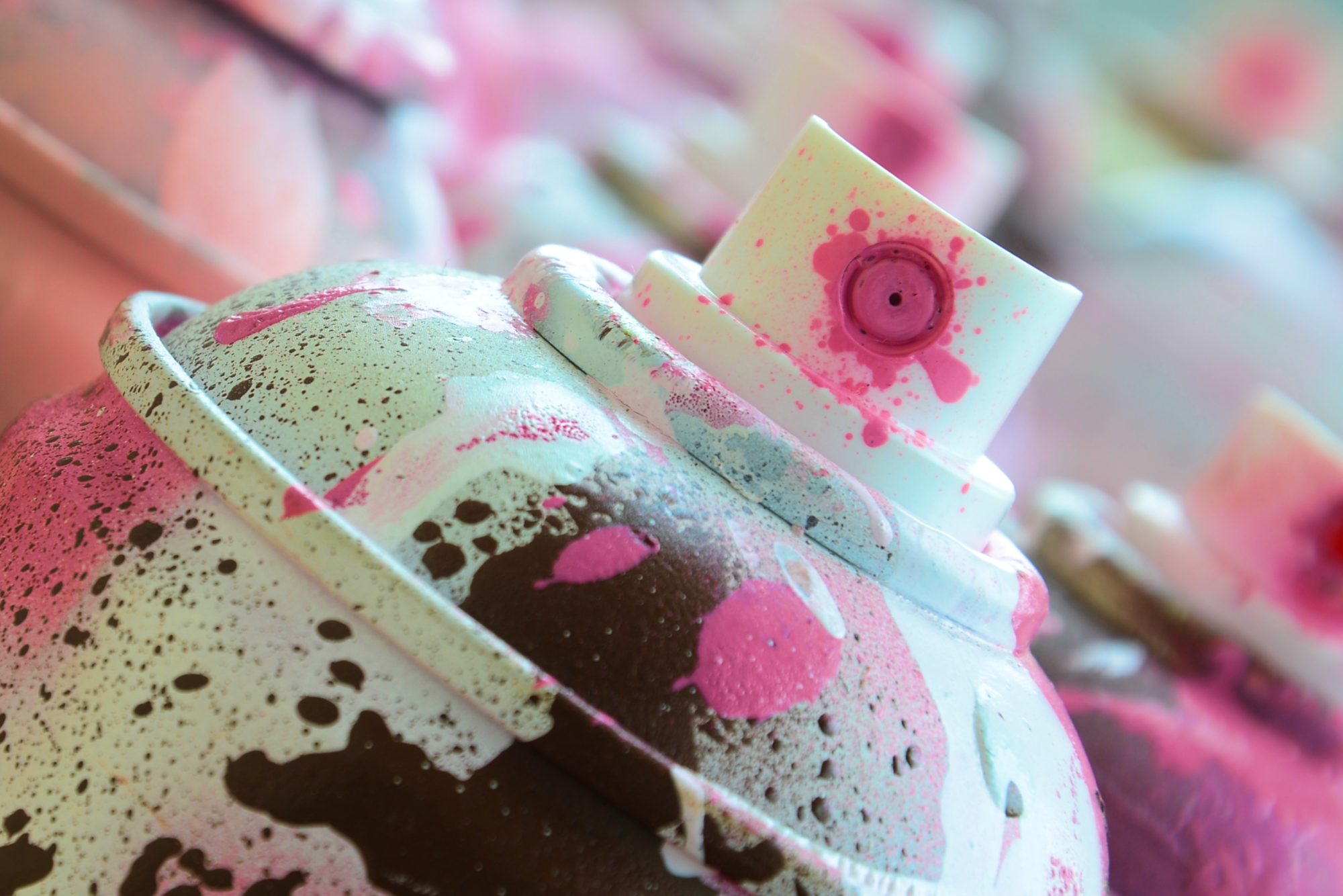 Close-up image of spray paint in shades of white and pink.