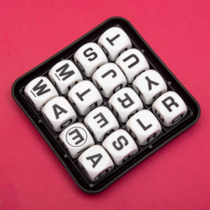 Image of a Boggle set against a dark pink background.
