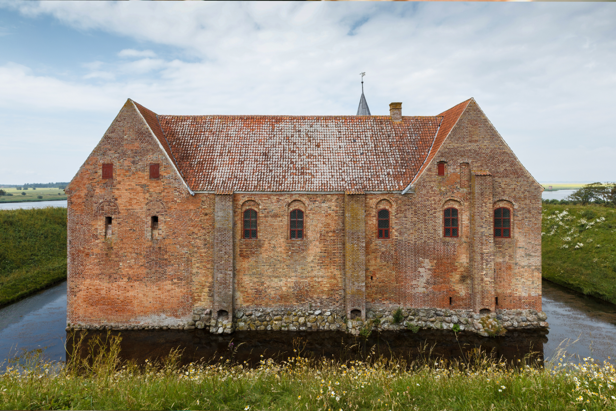 Image of an old house surrounded by a moat.