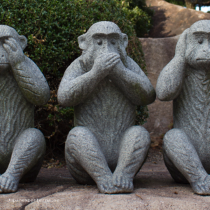 Image of a statue featuring three monkeys doing the see no evil, speak no evil, hear no evil poses.