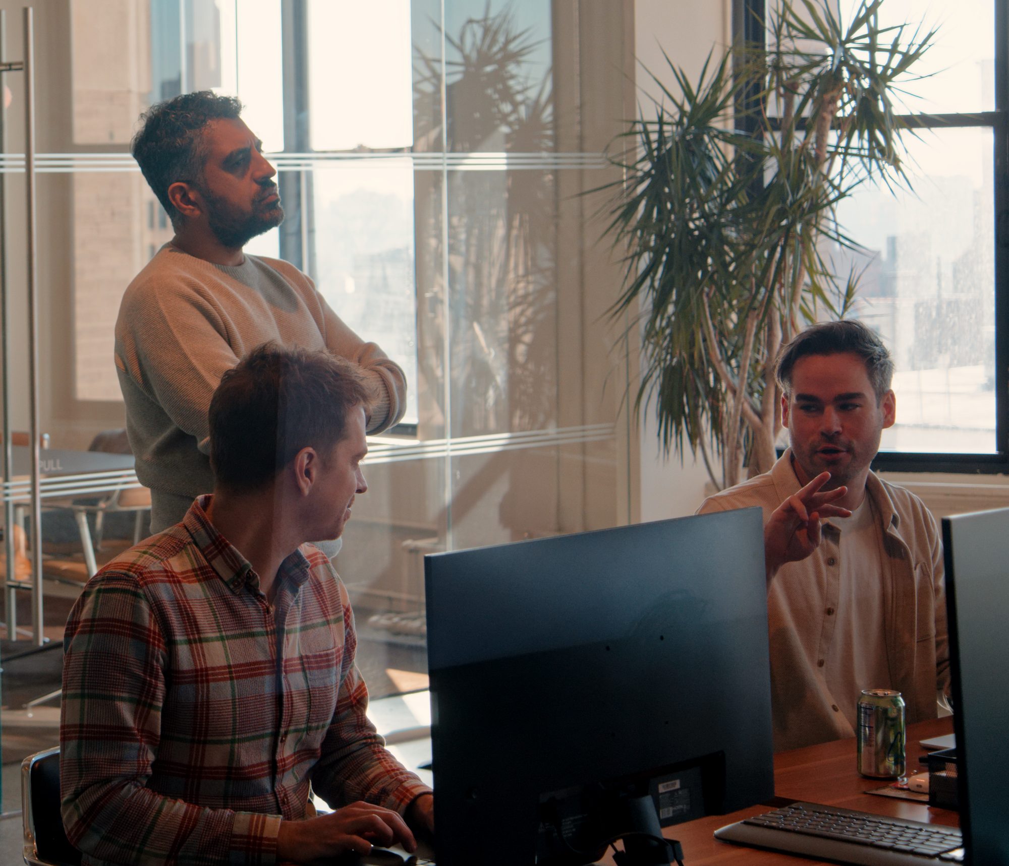 Three members of the Aboard team working through a problem together at a desk