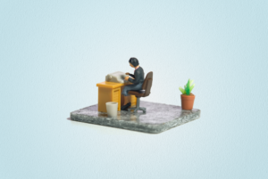 A miniature tableau featuring an office worker typing at a desk. A potted plant and tiny trash bin are on the floor.